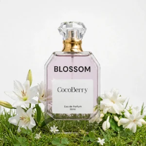 Blossom Eau de Parfum 50ml by CocoBerry in a clear glass bottle with a gold spray cap, surrounded by white lilies and jasmine flowers on a green grass background – Gucci Bloom Perfume