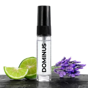 CocoBerry Dominus 5ml tester perfume bottle on dark stone with fresh lime slices and a sprig of lavender.