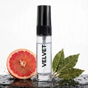 CocoBerry Velvet 5ml tester perfume bottle standing on a wet dark surface with a sliced pink grapefruit and water splashes.